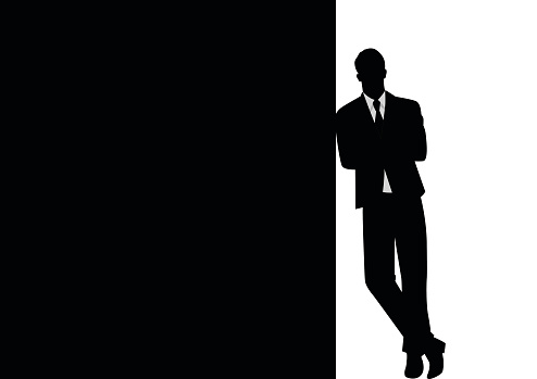 Silhouette of a businessman leaning at black blank space for copy with arm crossed