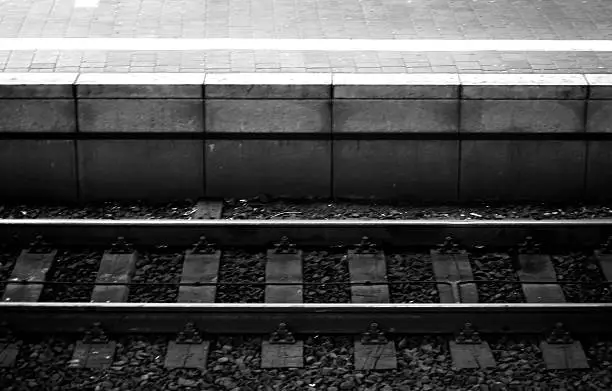 The top view on a track bed with rails and ballast stones.