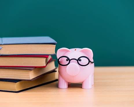 A piggy bank and stack of books.