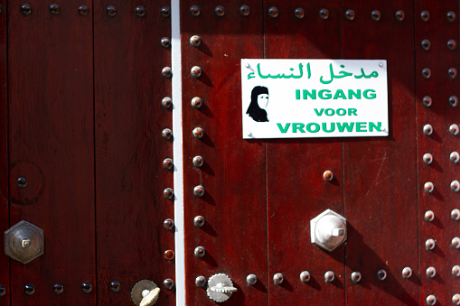 Haarlem, The Netherlands - August 3, 2012: Mosque doors with a sign showing a woman in hijab and text that reads, in Arabic and Dutch, \