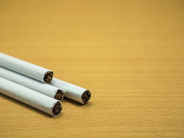 istock cigarettes on wooden background and copy space 535481388
