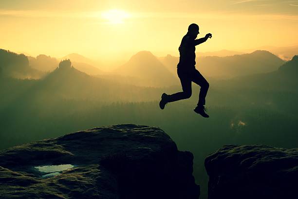 istock Crazy hiker jump between cliffs. Amazing mountains, heavy mist 535481706