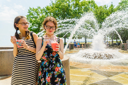 Two teenager girls eats the italian icecream next to fountain in the Waterfront Park in Charleston, South Carolina
