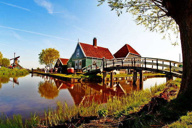 scena niderlandzkiej wioska, wiatrak i domek, w zaanse schans - netherlands windmill farm farmhouse zdjęcia i obrazy z banku zdjęć