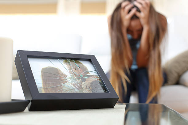 Sad wife or girlfriend after a breakup Sad desperate wife or girlfriend after a breakup sitting in a couch at home crying photos stock pictures, royalty-free photos & images