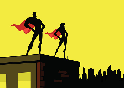 A flat color silhouette illustration of a superhero couple on top of a building with a city skyline in the background. Wide copy space available for your text.