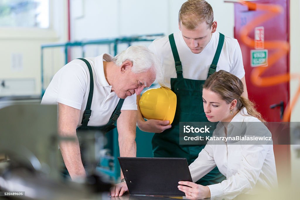 Manager talking with plant workers Young female manager talking with plant workers 2015 Stock Photo