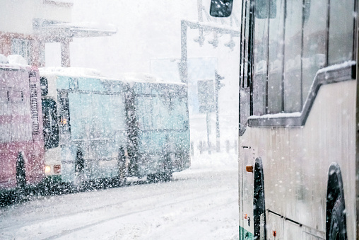 Snowy European day traffic, buses, public transportation.