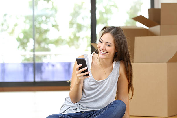 istock Woman moving home texting in a smart phone 535501320