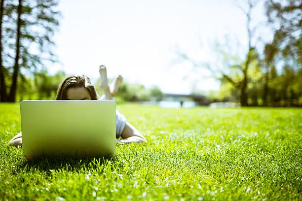 Photo of Young woman working on laptop in parc