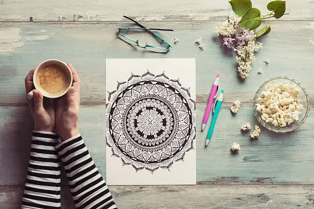 Photo of Flat lay, female coloring adult coloring books, stress relieving trend