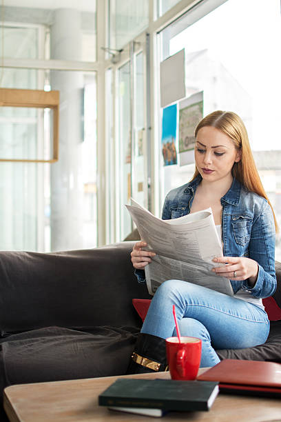 istock Young woman reading newspaper and having coffee break. 535509686