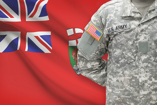 American soldier with Canadian province flag on background - Manitoba