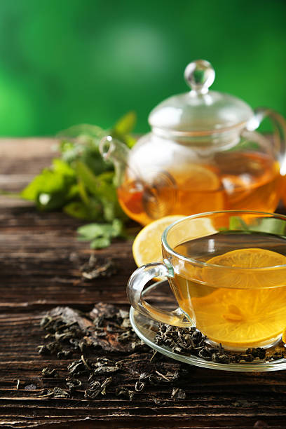 istock Cup with green tea and teapot on brown wooden background 535513617