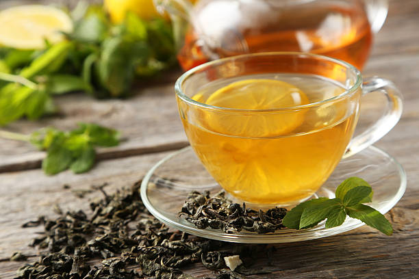 istock Cup with green tea and teapot on grey wooden background 535513629