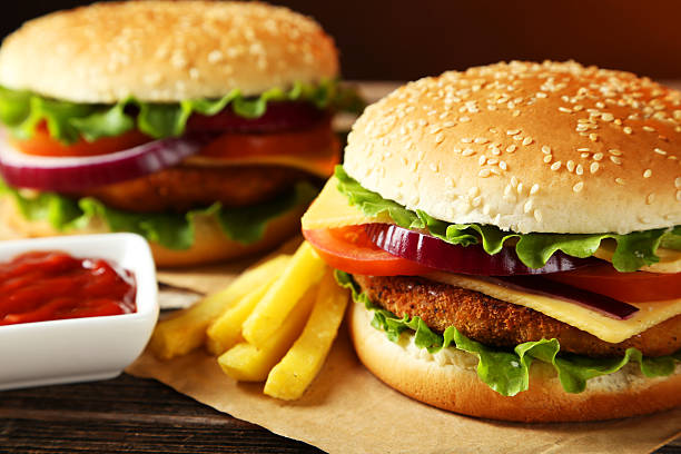 istock Fresh burgers on brown wooden background 535514919
