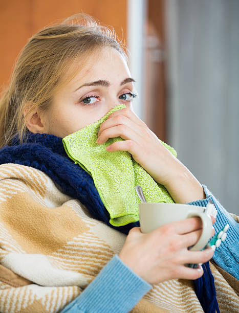 istock Adult female under blanket with flu attack indoors 535518348