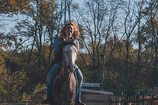 istock Pretty girl riding her grey horse 535522332
