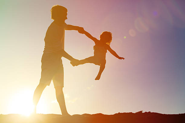 istock Father and little daughter playing silhouettes at sunset 535524154