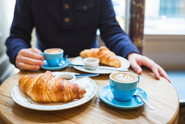 café et un croissant. français petit déjeuner pour deux personnes (paris, france) - cafe breakfast coffee croissant photos et images de collection
