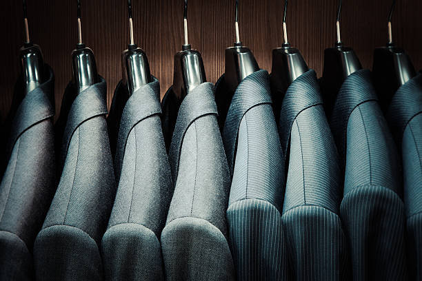 Row of men suit jackets on hangers in store