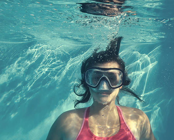 istock Girl swimming underwater in pool. 535537483