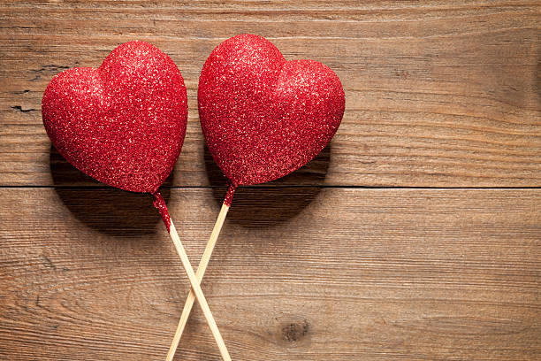 istock Glitter hearts on old wooden table 535538133