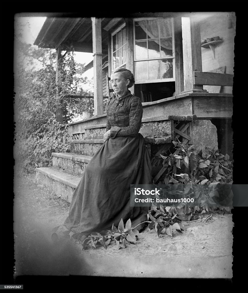 The Farmer's Wife, Circa 1890 Beautiful Black and White portrait of an American Farmer woman wearing Victorian-era clothing. Taken on the front porch of her farmhouse dressed in her best clothes--probably on a Sunday afternoon. The image was digitally restored from a glass plate taken circa 1890. Women Stock Photo