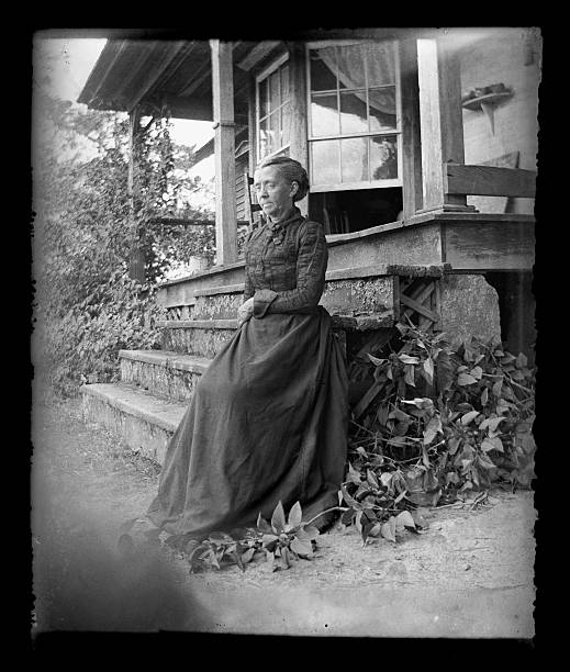 The Farmer's Wife, Circa 1890 Beautiful Black and White portrait of an American Farmer woman wearing Victorian-era clothing. Taken on the front porch of her farmhouse dressed in her best clothes--probably on a Sunday afternoon. The image was digitally restored from a glass plate taken circa 1890. 19th century style photos stock pictures, royalty-free photos & images