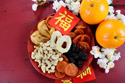 Happy Chinese New Year celebration party tray of togetherness on red wood background.