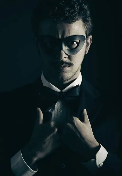 vintage style elegant superhero wearing a suit with bow-tie and a black mask.