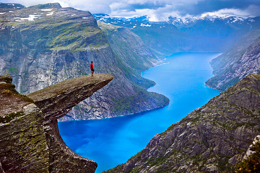 Trolltunga, Norway - july 30, 2014: Trolltunga rock with a characteristic shape located in Norway on the border of the Hardangervidda plateau, close to the town Tyssedal. It is a popular tourist attraction in Norway and heavily visited by tourists during the summer months. 