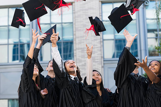 Group of students at graduation, tossing caps