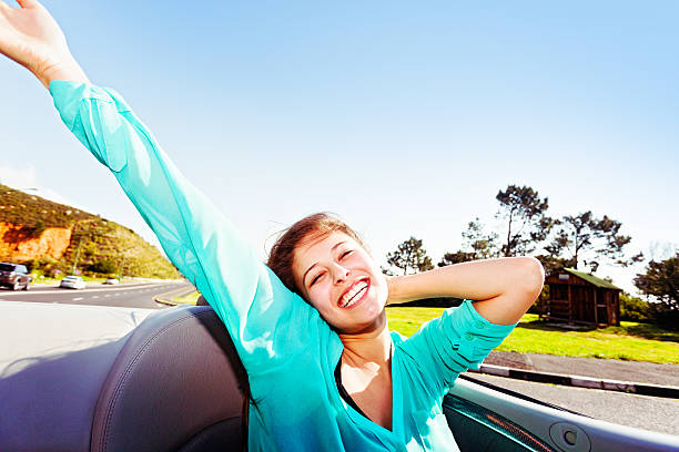 belleza joven disfrutando de ser impulsado a convertible en día de verano - correspondence waving horizontal outdoors fotografías e imágenes de stock