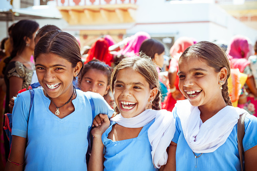 Sabbalpura, India - March 15, 2014: Group of happy indian school girls wearing blue school uniforms posing in the rural village, Rajasthan, India.