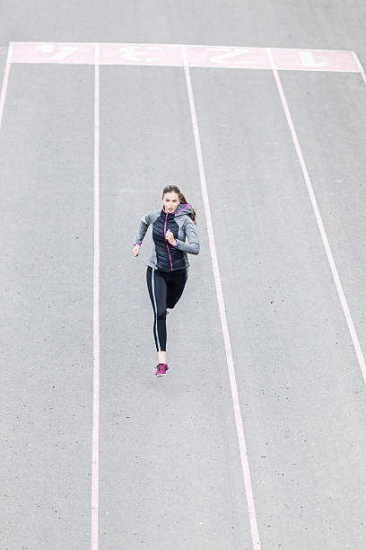 istock Young woman running on sport track 535555852