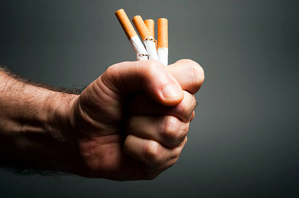 Cigarettes in fist stock photo