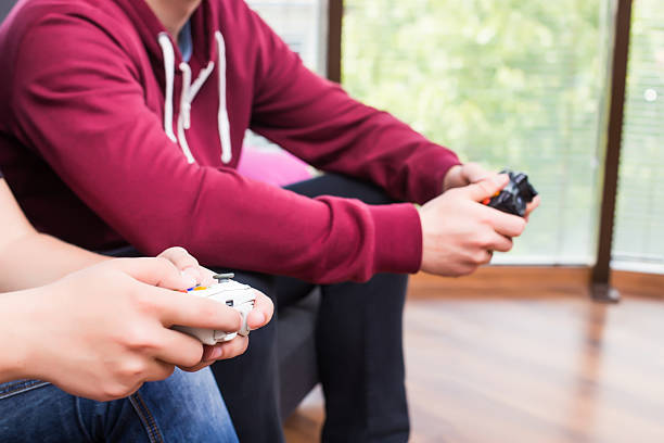 acercamiento de manos con consola de videojuegos. - video game friendship teenager togetherness fotografías e imágenes de stock