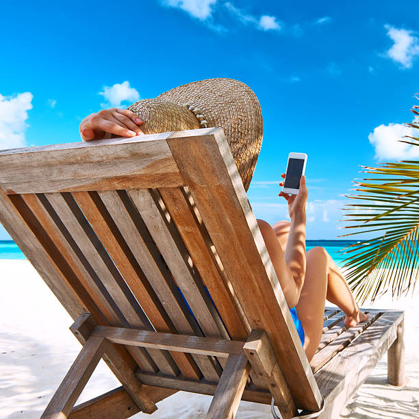 istock Young woman with mobile phone at the beach 535565099