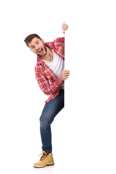 istock Happy man jumping out from behind white banner 535567941