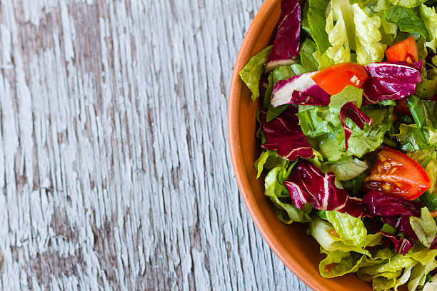 istock Appetizing tomato salad in bowl on wooden table 535568247