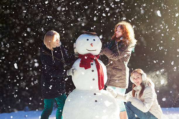 istock Three girls building a snowman 535568911