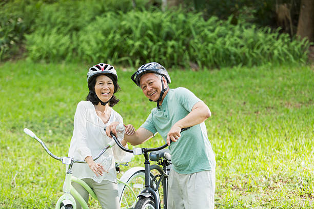 montar bicicletas de pareja senior - action mature adult bicycle senior couple fotografías e imágenes de stock