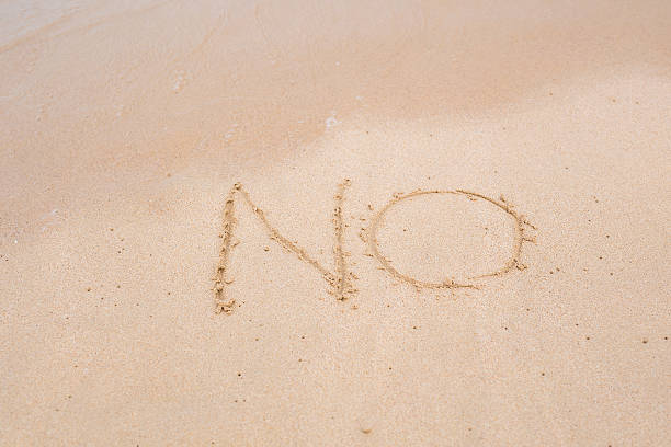 istock NO sign written in sand on beach texture sunny background 535578692