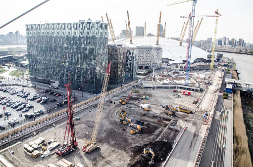 Aerial view of Emirates Greenwich peninsula with the O2 complex center and construction cranes,
