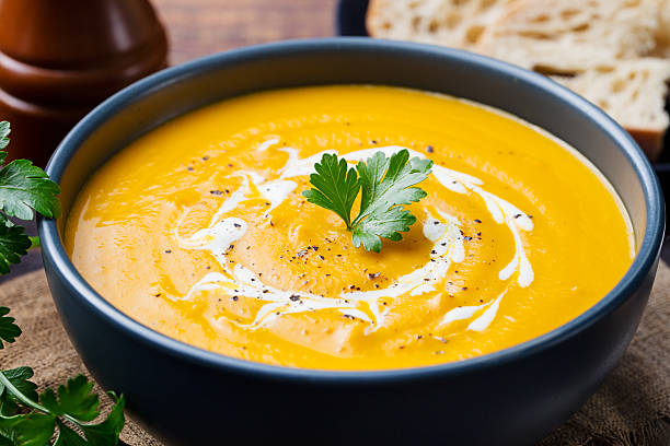 istock Pumpkin and carrot soup with cream and parsley 535581994