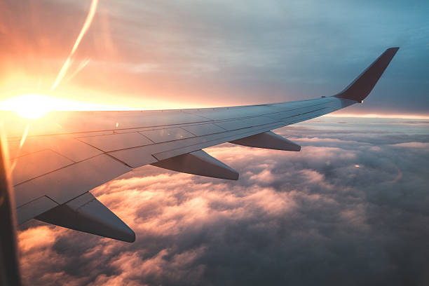 Above the clouds. View from the window of an airplane at sunset. Aircraft Wing. passenger cabin photos stock pictures, royalty-free photos & images