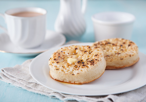 Hot buttered crumpets on the blue table with tea