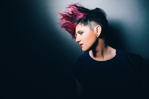 Fashion portrait of a young woman with a mohawk hair do