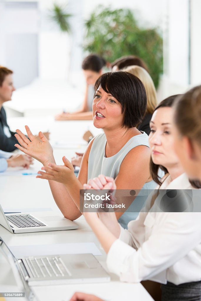 Group of businesswomen at meeting Group of businesswomen brainstorming, working together and discussing. Job Fair Stock Photo